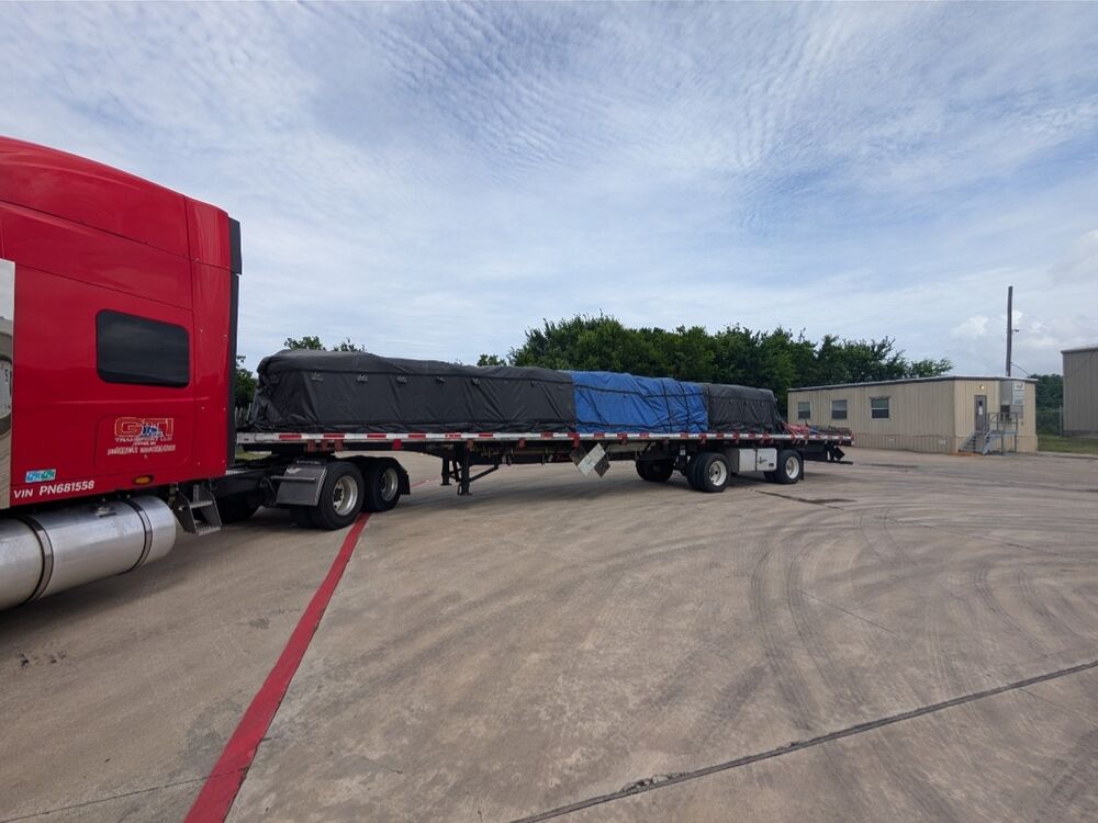 A GTI Transport flatbed with tarped and sheeted freight